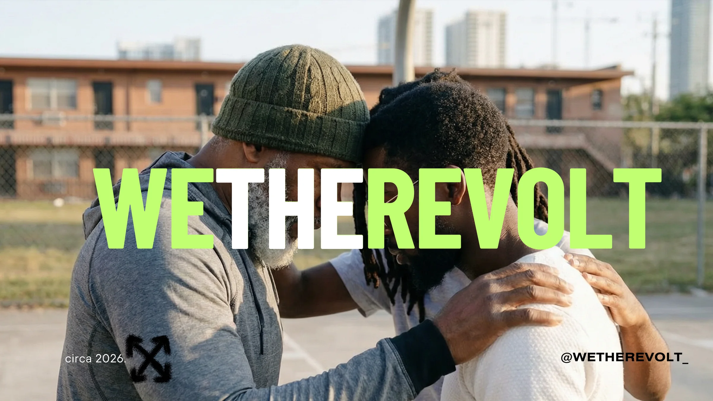 Two men embrace on a Miami street under the We The Revolt name