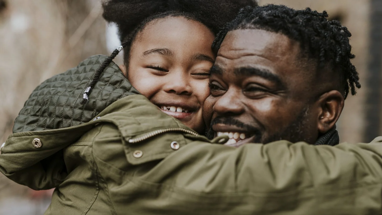 A young father hugs his smiling son