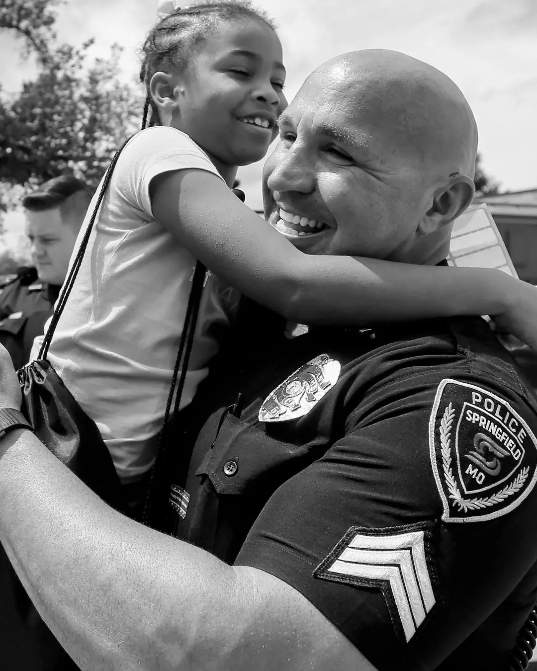 A police officer hugs a smiling girl