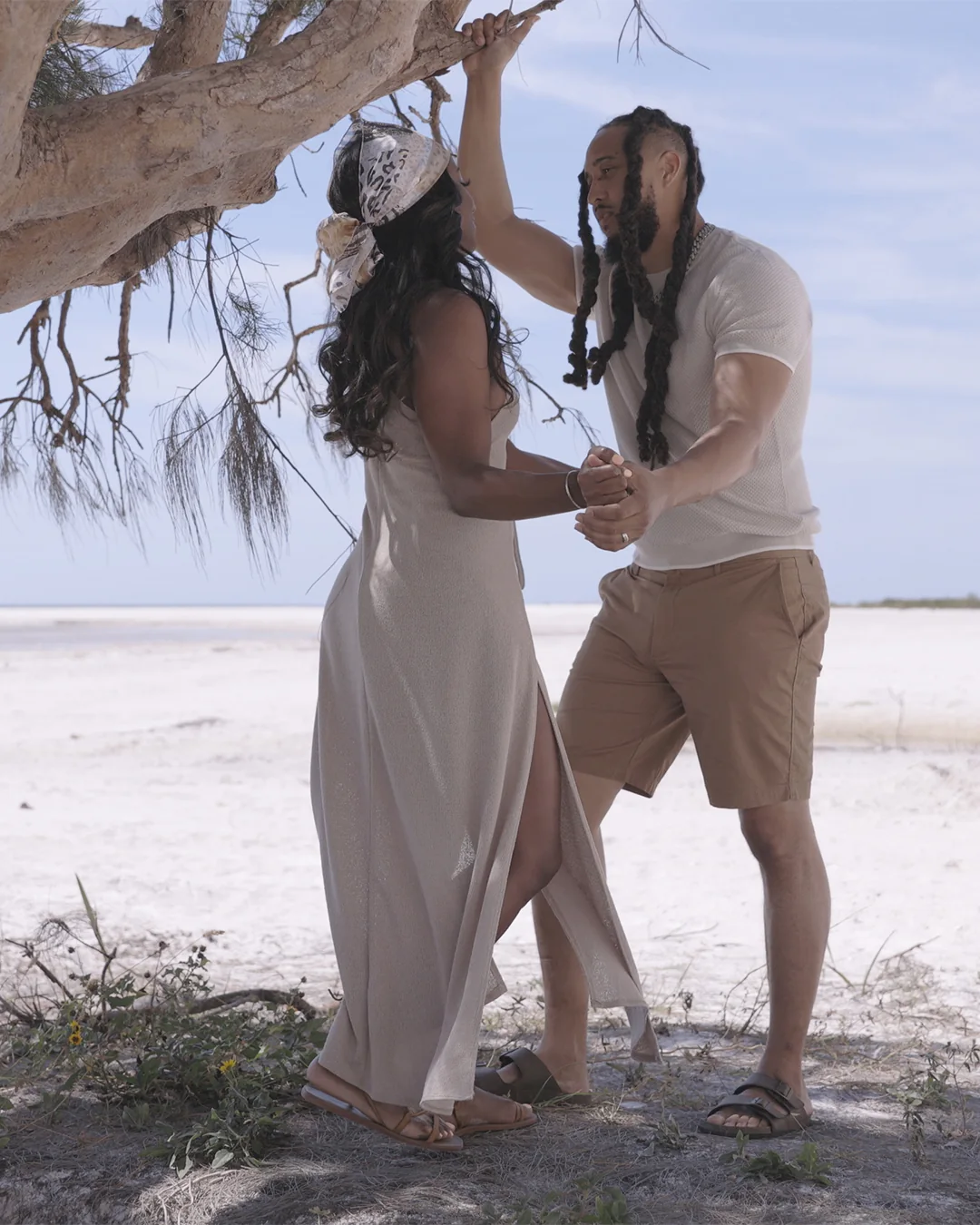 Ronnie and Christine Lillard dance under a tree on a white sand beach