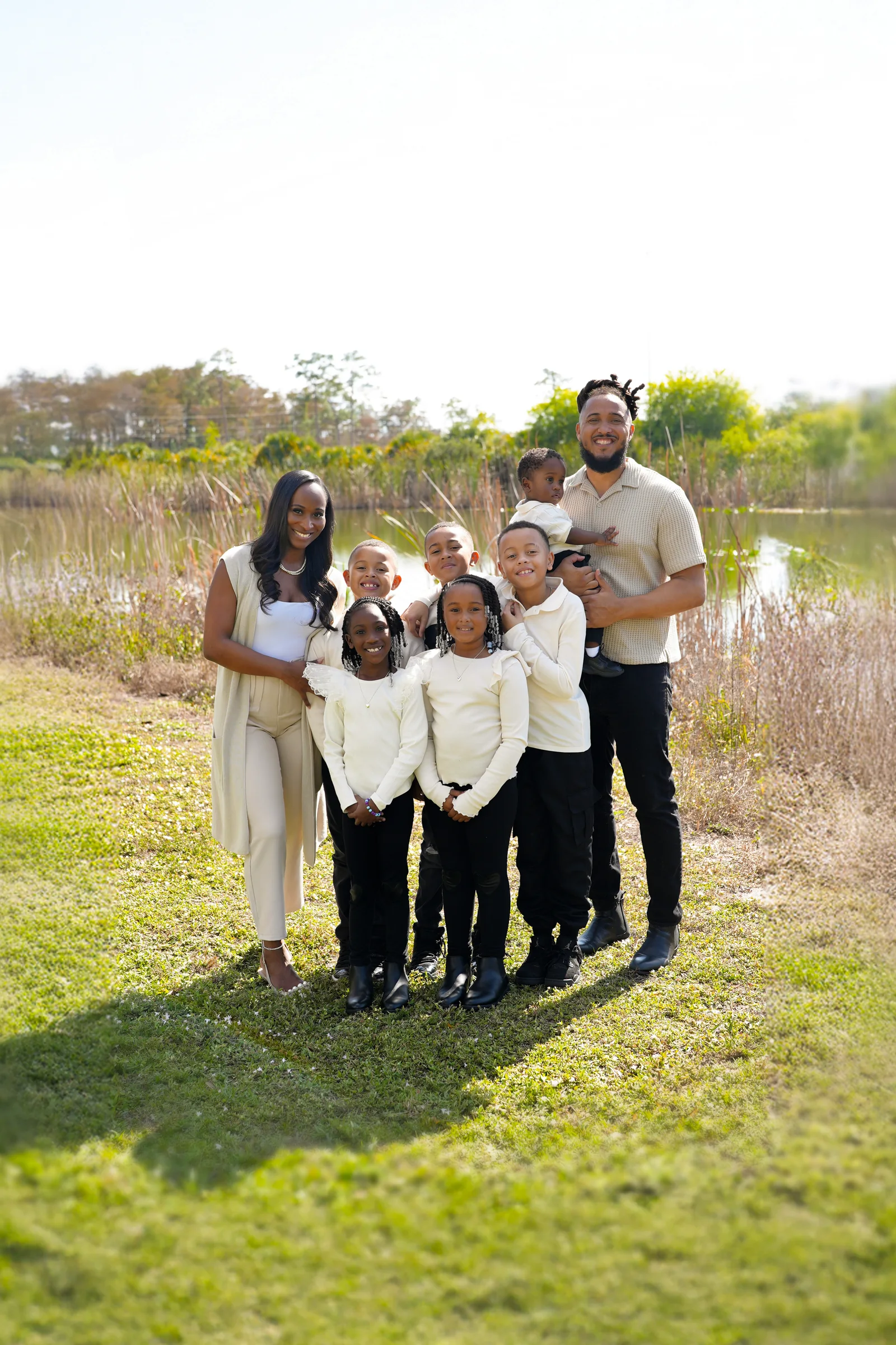 Ronnie Lillard holds his youngest son beside his wife, Christine, and their children in front of a pond