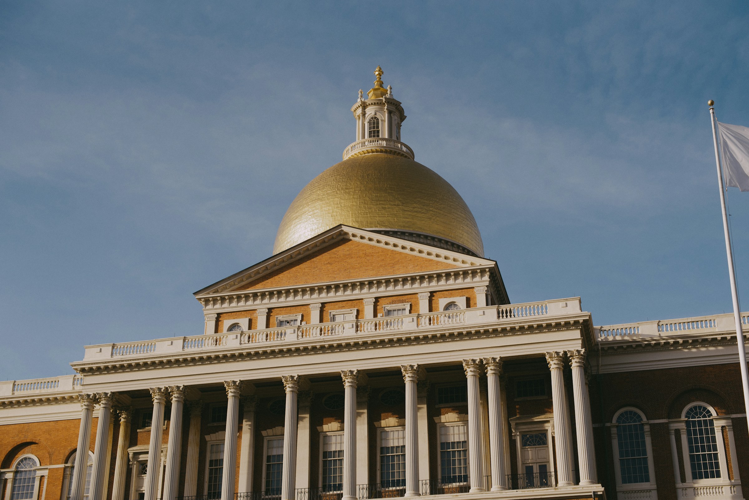 The gold-domed Massachusetts State House in Boston against an autumn sky.